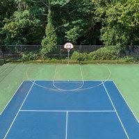 A blue tennis court with a white line in the middle and a red and white sign on the side.